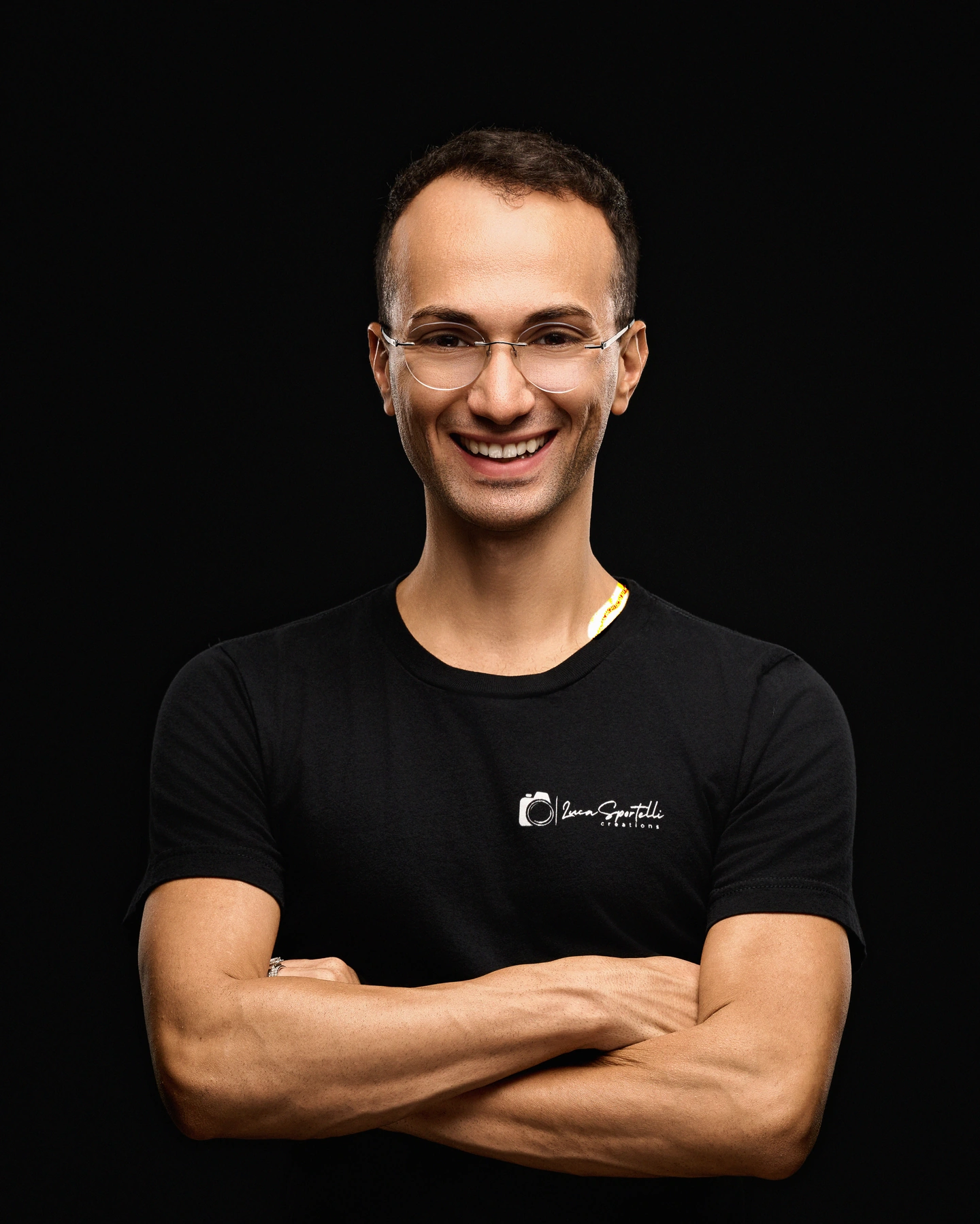 Luca Sportelli smiling with his arms crossed, wearing his Luca Sportelli Creations studio shirt